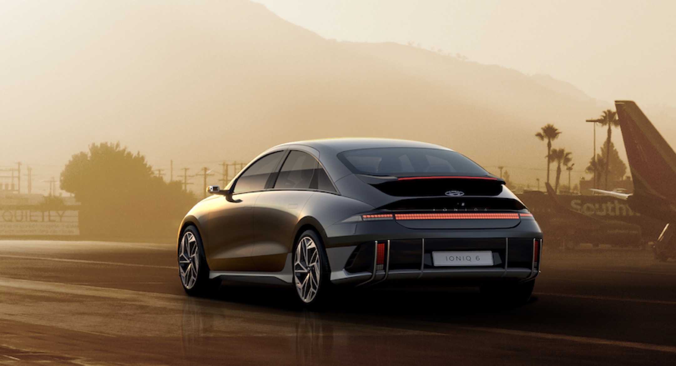 Dark coloured Hyundai Ioniq 6 at airbase during sunset rear view 